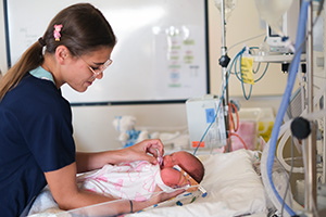 A female registered nurse holds a newborn baby