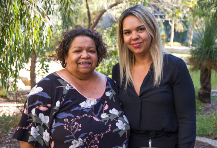 Two Aboriginal women stand in a garden setting